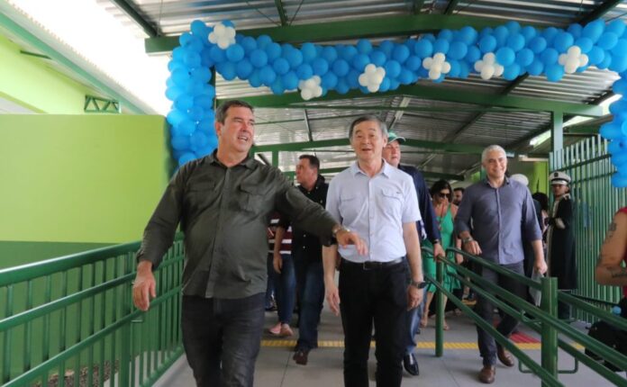 Bodoquena recebe novas obras de educação e saneamento para melhorar Governador de camisa verde anda na escola ao lado do prefeito de camisa azul clara. Atrás deles balões enfeitam a escola recém inaugurada